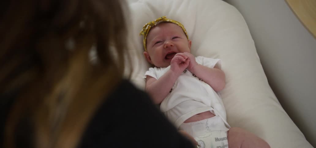 A baby cries on a changing table