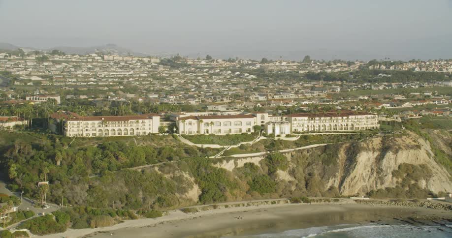 Large buildings sit at the edge of the shoreline cliff