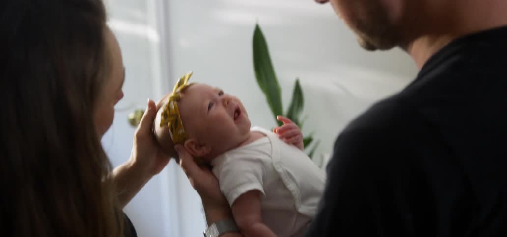 A mother and father soothe their crying baby