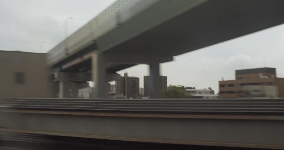 The train moves past the buildings on a platform