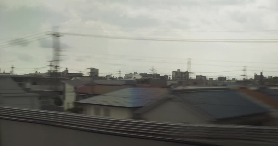 Vehicle drives down a road in a city on a cloudy day
