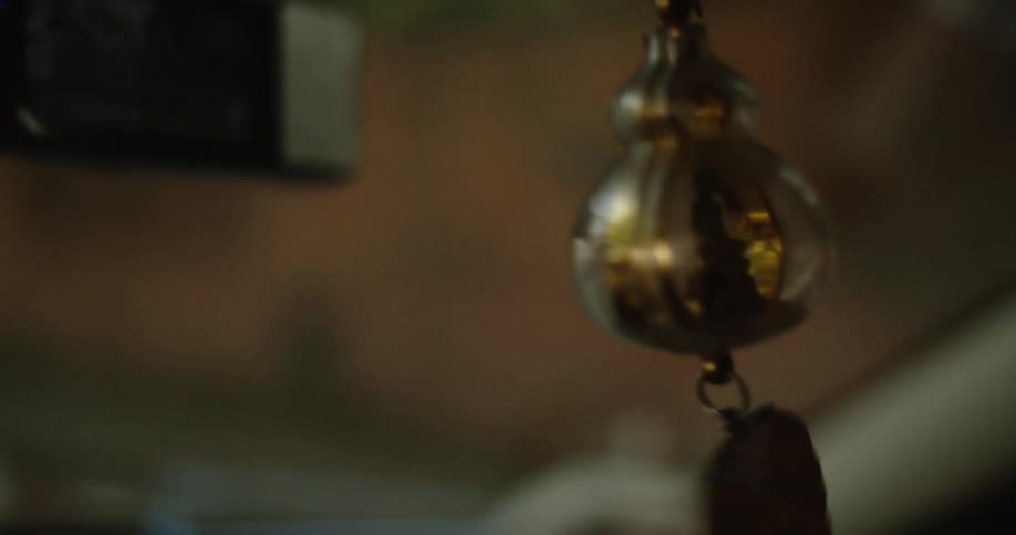 A charm hangs from a car rear view mirror