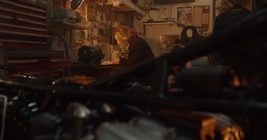 A man is flipping through pages at a workbench