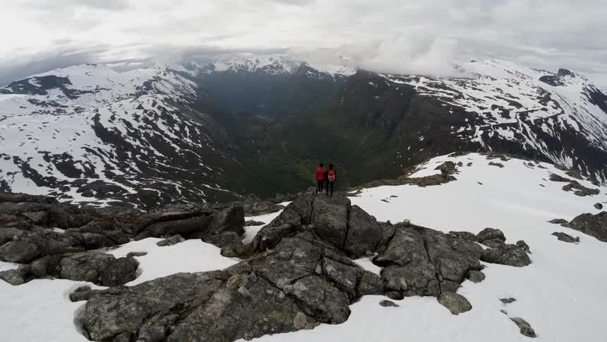 Two people standing on a mountain top