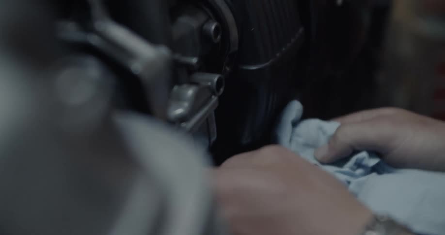 A man wipes a motorcycle with a cloth