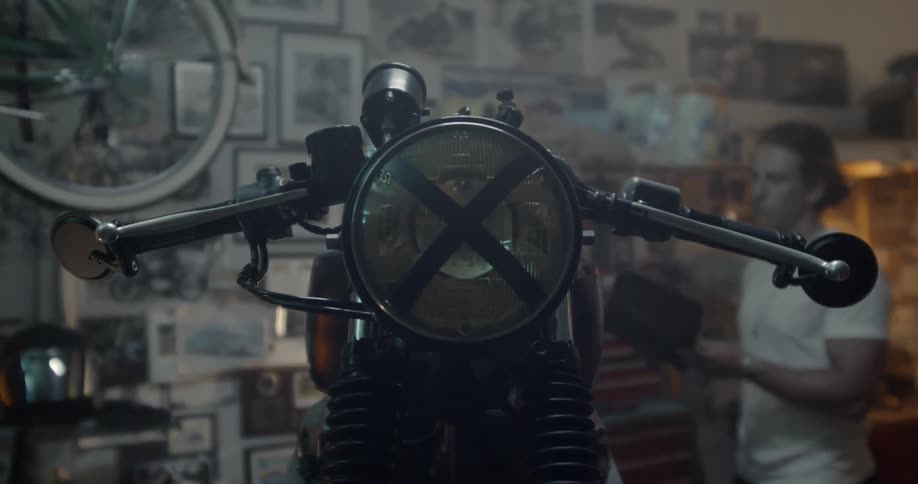 A man is working in his garage on a motorcycle