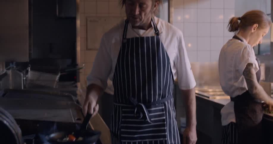 Two chefs work in a restaurant kitchen