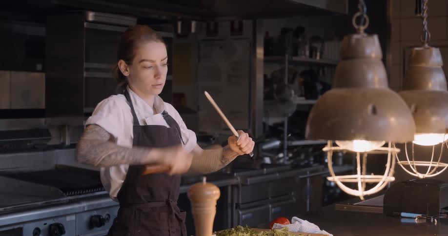 A chef sharpens a knife in a restaurant kitchen
