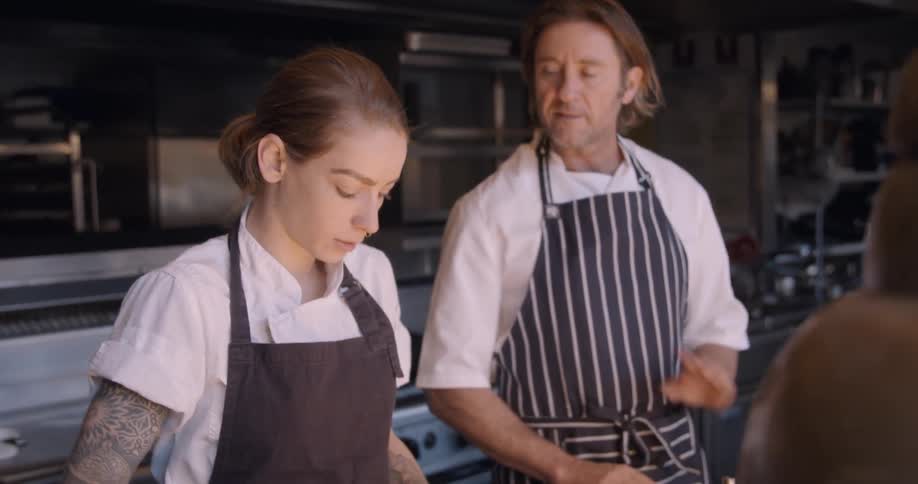 Two chefs work in a restaurant kitchen