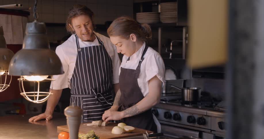 Two chefs work in a restaurant kitchen