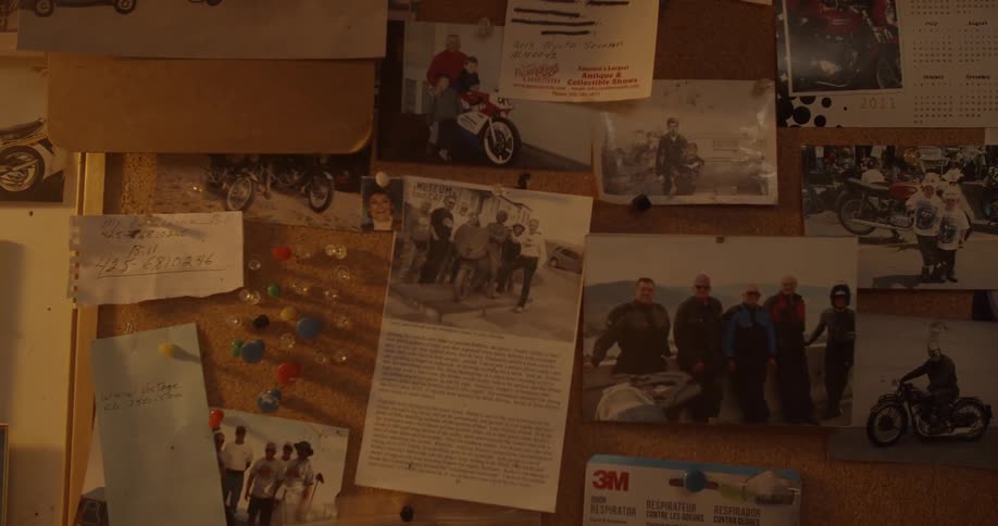 Pictures and papers are hung up on the wall