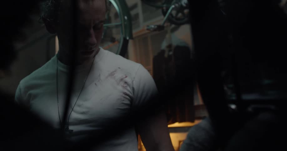 A man wipes his hand off on his shirt