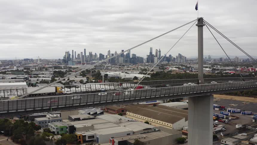 Cars are crossing a bridge in large city