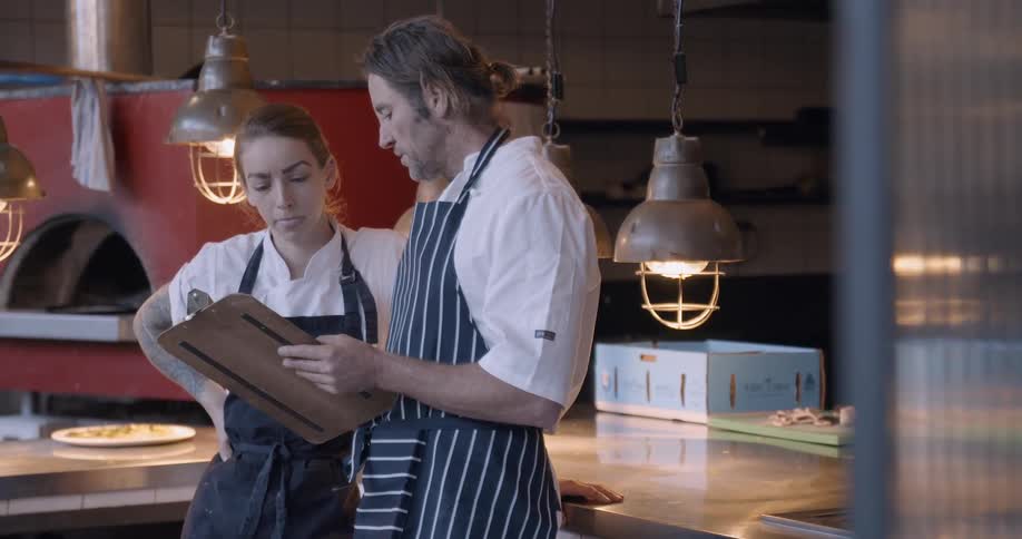 Two chefs work in a restaurant kitchen