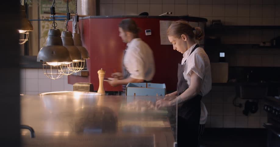 Two chefs work in a restaurant kitchen