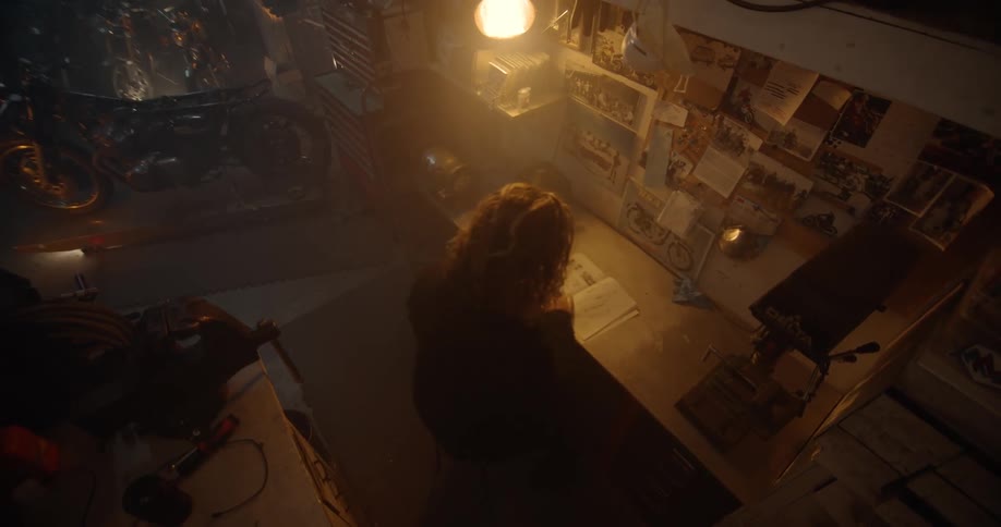 A person reads a book at a garage desktop