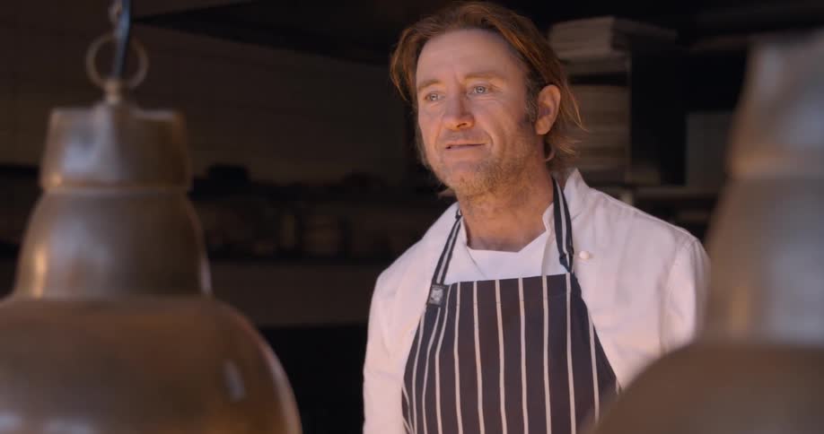 A chef talks and smiles