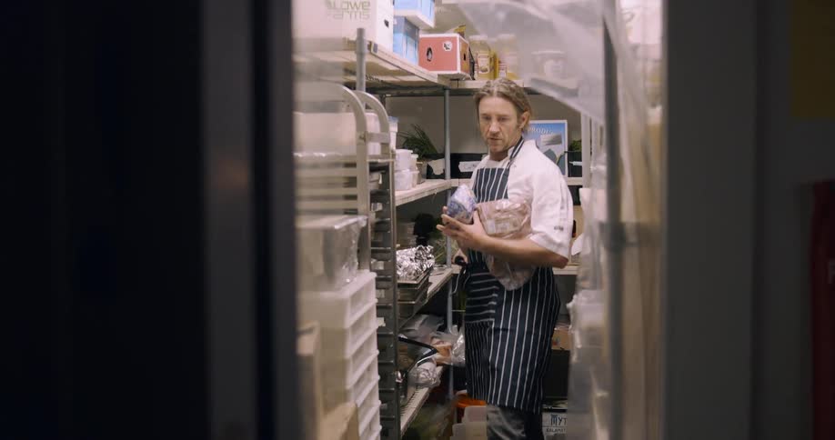 A chef grabs ingredients from a storage room