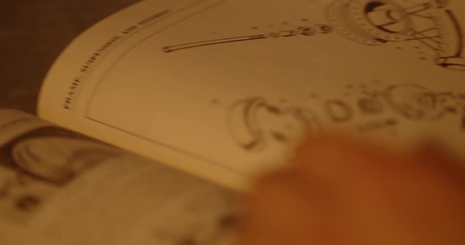 Person is flipping through an automobile manual