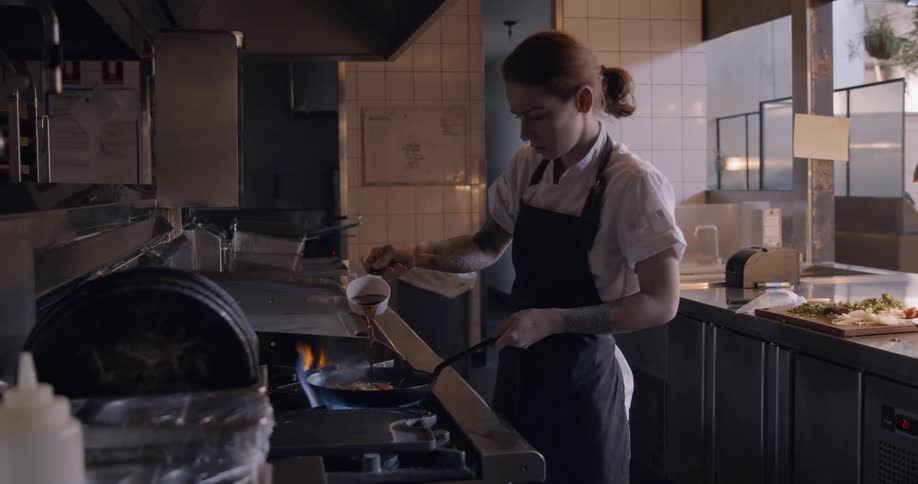 A woman is cooking with a pan