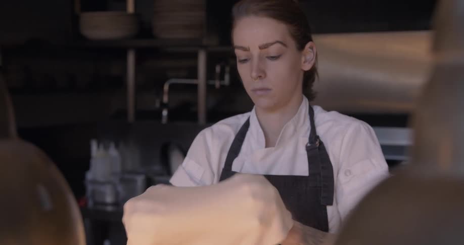 A chef makes pizza dough in a kitchen