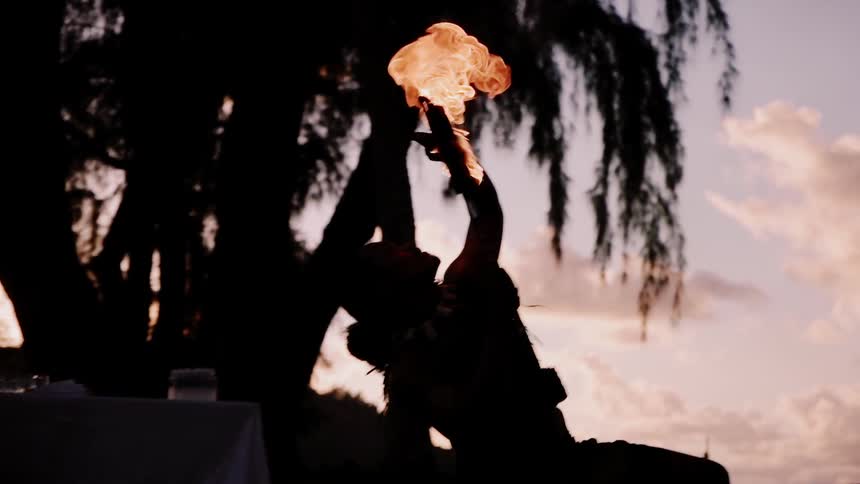 Fire dancer performing at sunset