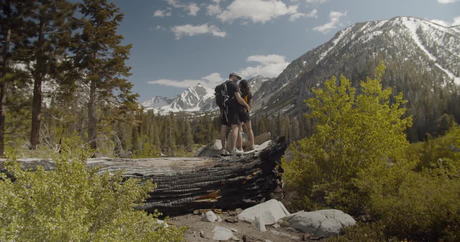 A man and woman embrace in the wilderness
