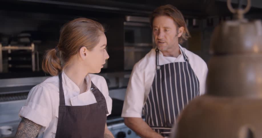 Two chefs work in a restaurant kitchen