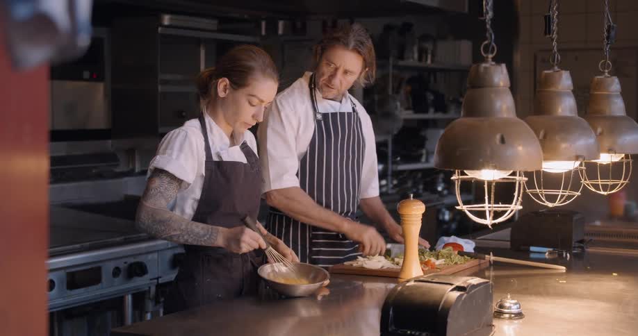 Two chefs work in the kitchen