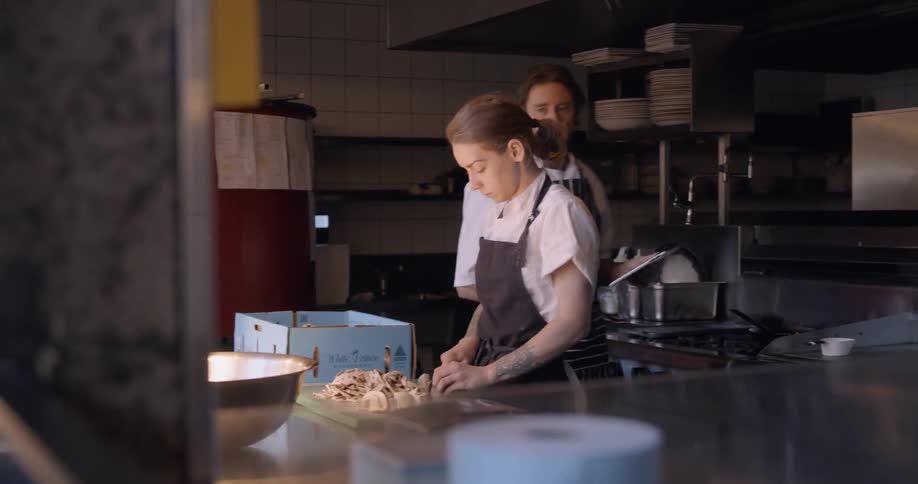 Two chefs are working in the kitchen together