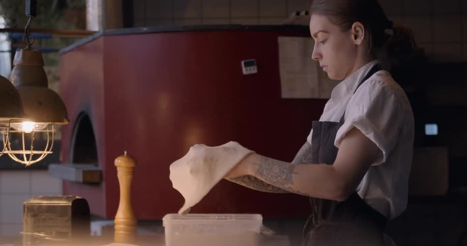 A chef makes pizza dough in a kitchen