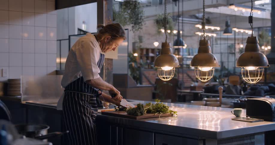 A chef chops food in the kitchen