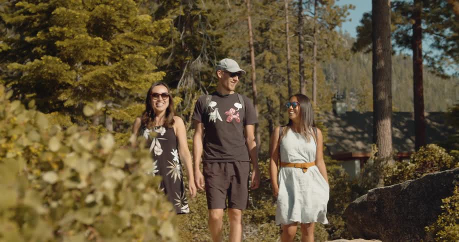 Friends are smiling and walking through forest greenery