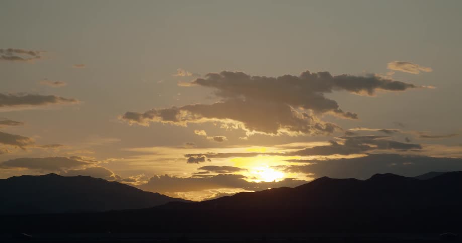 The sun shines through the sparse clouds
