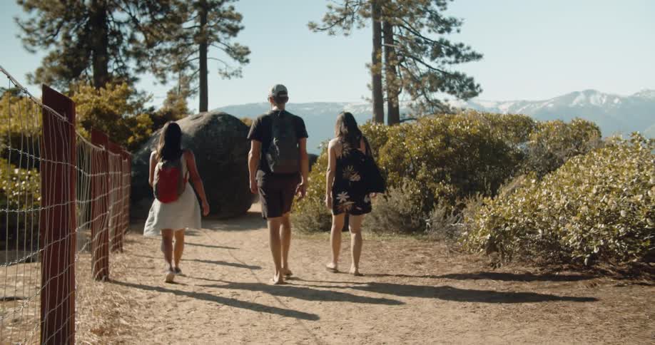 Friends walk down path towards lake