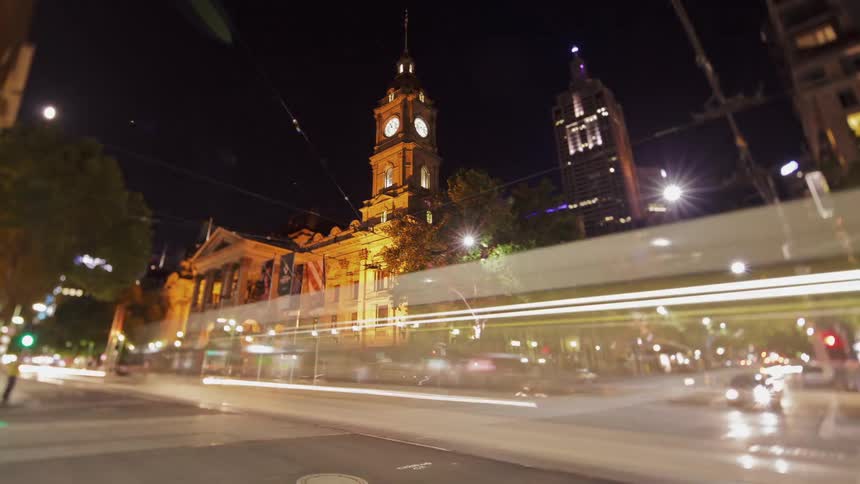 Cars drive on a city street at night