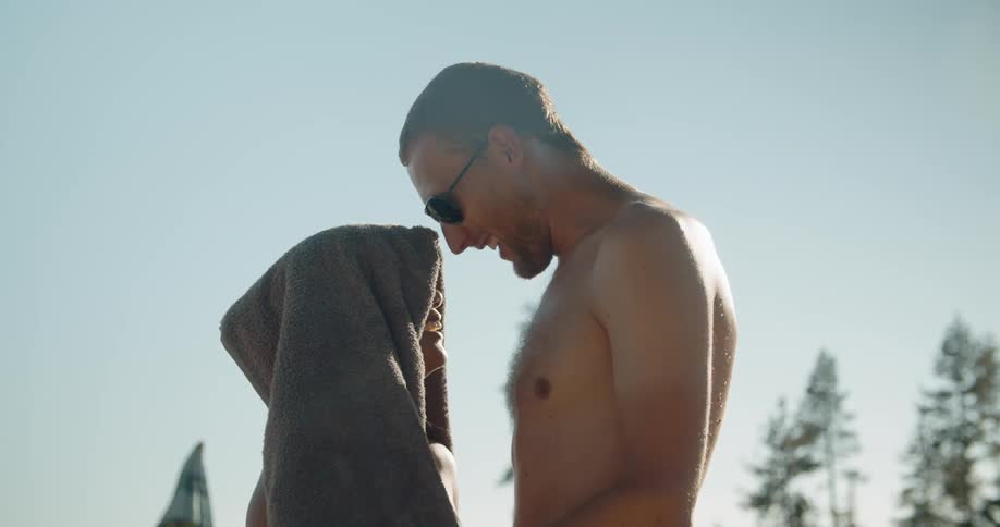 Man puts a towel over a woman's head