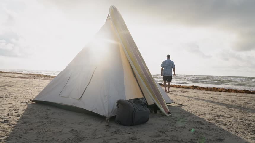 A man camps on a beach