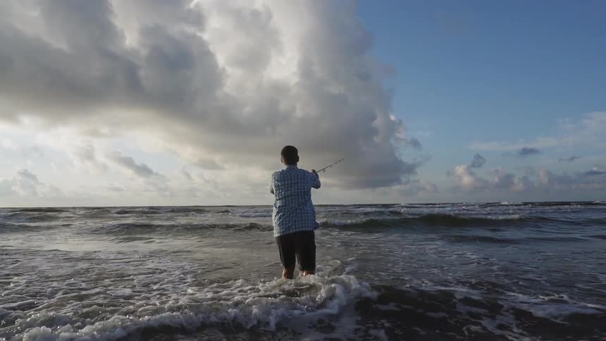 A man casts his fishing line in the water