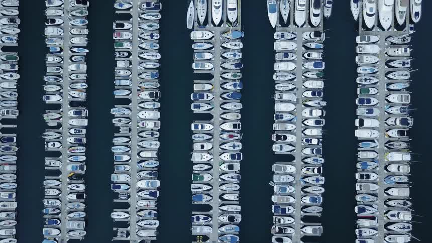 Boats are floating docked at slips in a marina in daylight