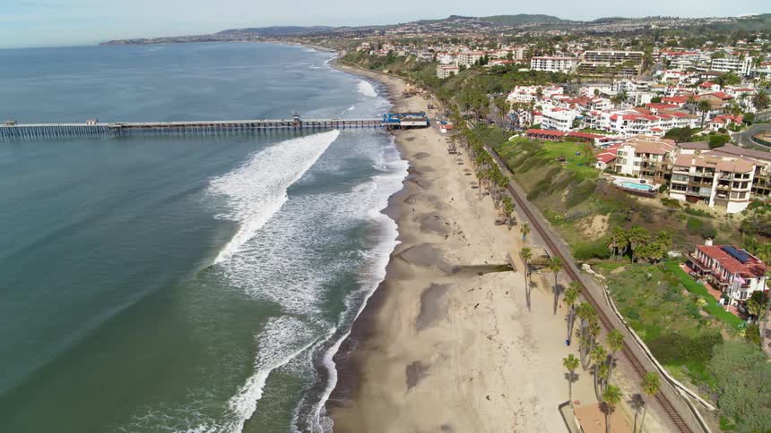 The beach is busy with many people near the town