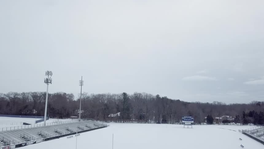 Snow covers the athletic field