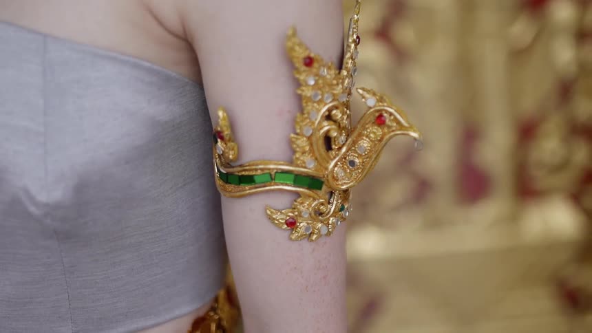 A woman is wearing gold jewelry