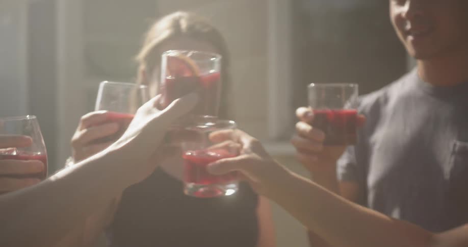 Group of friends toasting drinks outside