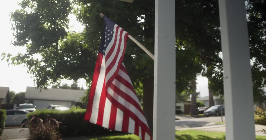 An american flag hangs from a house