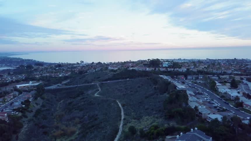The cars travel on the road downhill towards the town