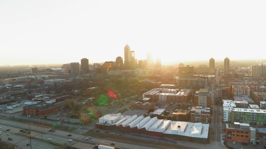 The cars drive past the city at sunset