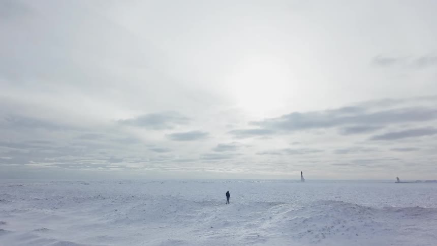 A person stands in a snowy field