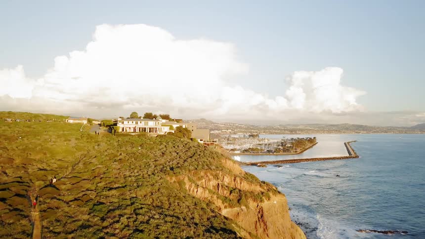 The tide flows towards the cliff lined shore