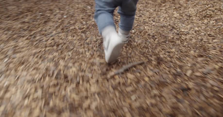 Young boy runs through a playground